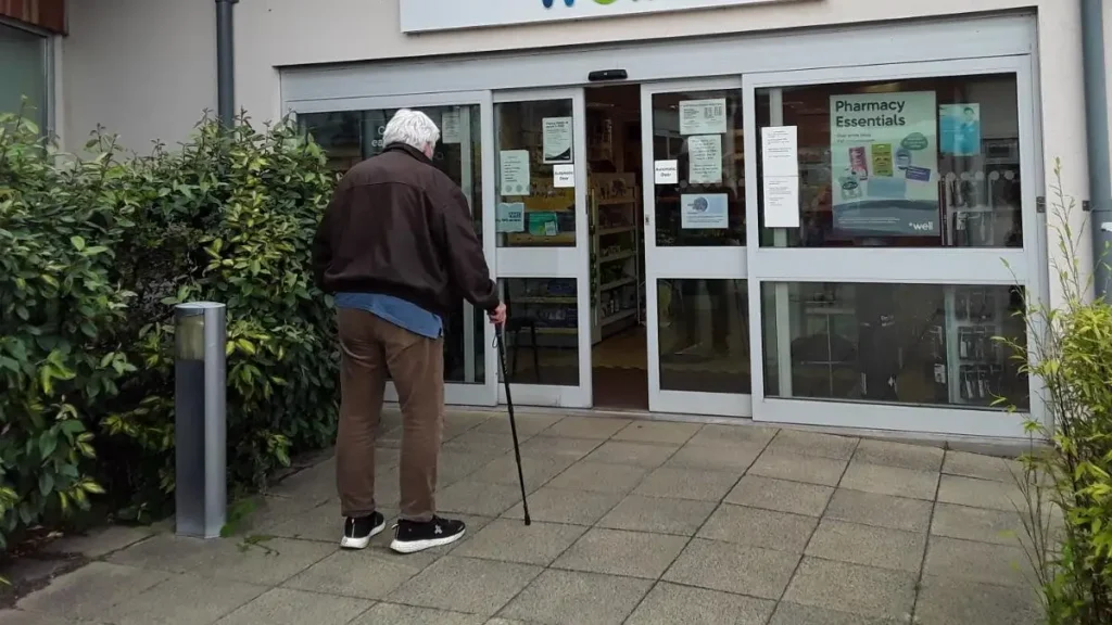 2. Is a Pharmacy Within Easy Reach?An older man uses a walking stick as he approaches a local pharmacy entrance. The image shows how convenient pharmacy access can support independence during retirement.Check the walking distance, entrance design, pavement, and opening hours. A pharmacy should remain easy to reach when mobility becomes limited or urgent medicine is needed.Measure the route from home
Check for steps and steep slopes
Look for automatic doors
Review opening hours
Ask about prescription delivery services