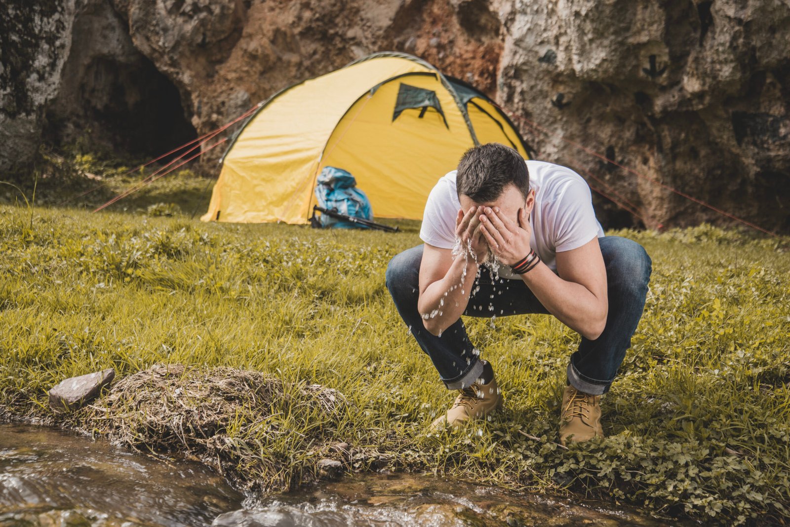 hiker-washing-his-face-river
